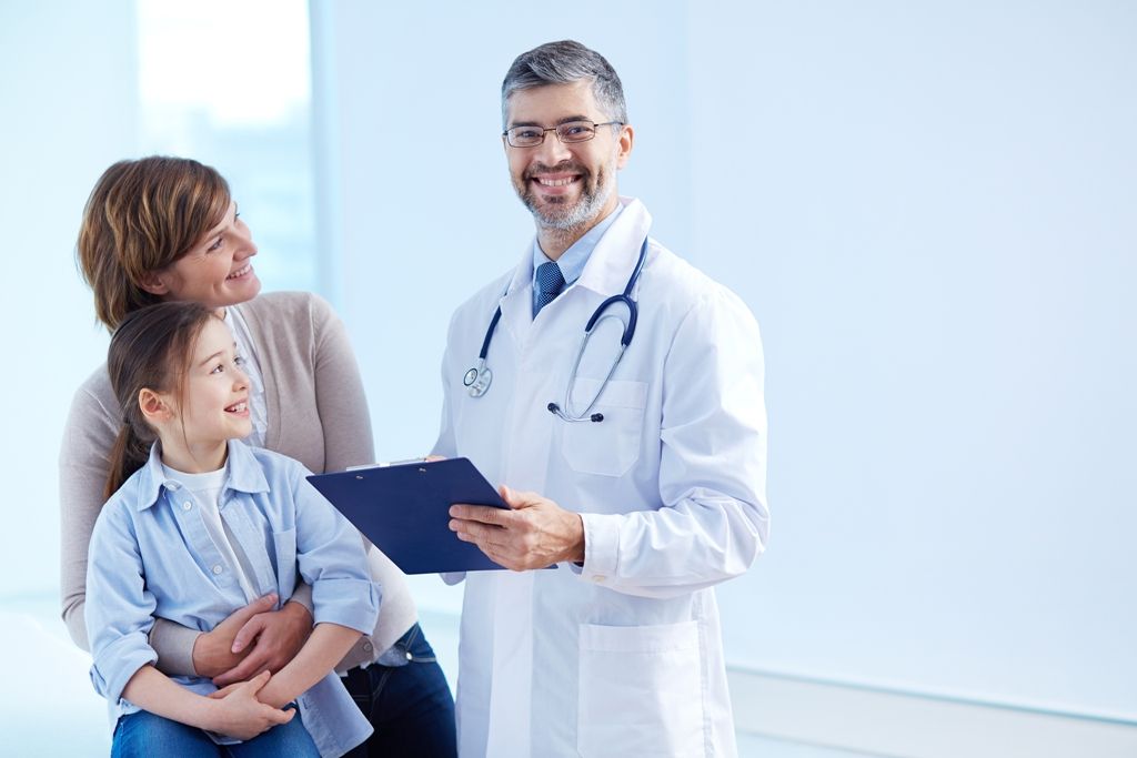 A doctor consulting with a mother and child at Amrit Hospital